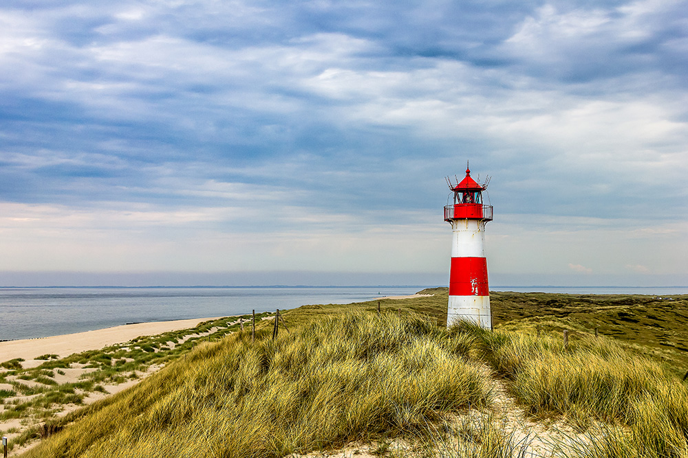 Papier peint photo - phare dans les dunes sur la côte sous un ciel nuageux