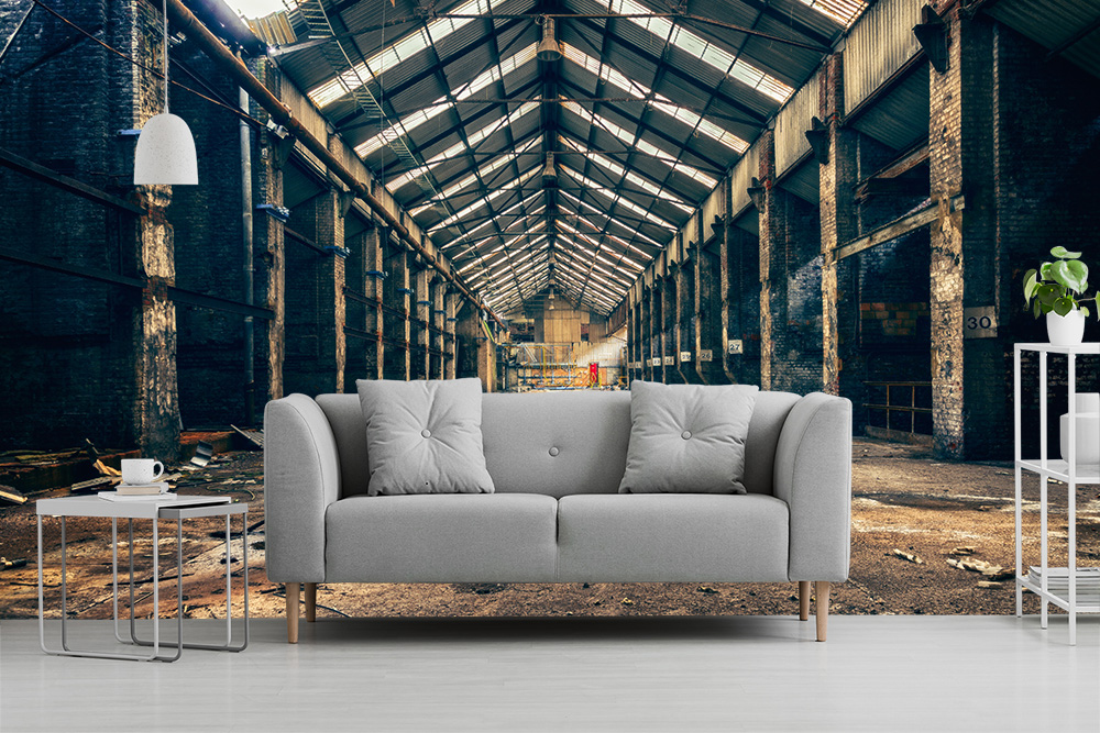 Papier peint photo - canapé devant une grande pièce d'un ancien atelier industriel aux murs hauts et au toit plat