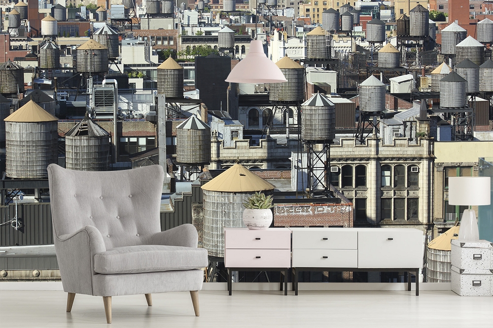 Papier peint photo - salon avec papier peint urbain de vue de la ville et des réservoirs d'eau, fauteuil gris et commode mid-century