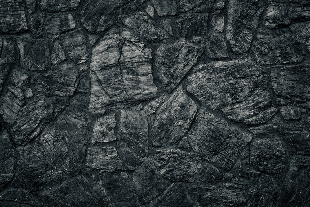 Papier peint photo - détail d'un mur de pierre sombre rustique à la texture naturelle
