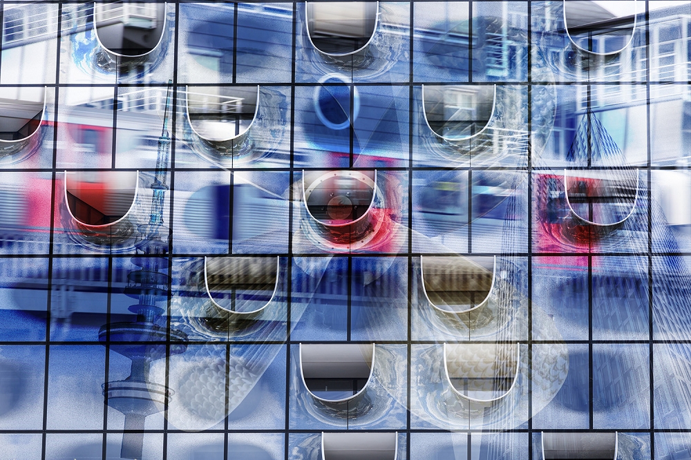Papier peint photo - Détail d'une façade moderne en verre avec des reflets colorés et des formes abstraites