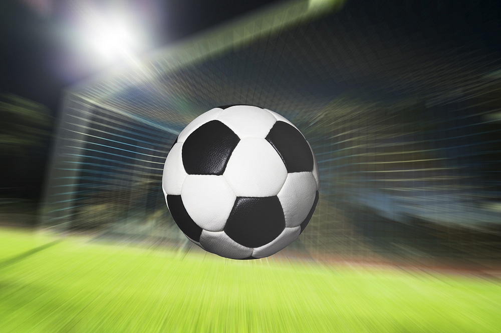 Papier peint photo - le football vole à toute vitesse vers un but, arrière-plan flou