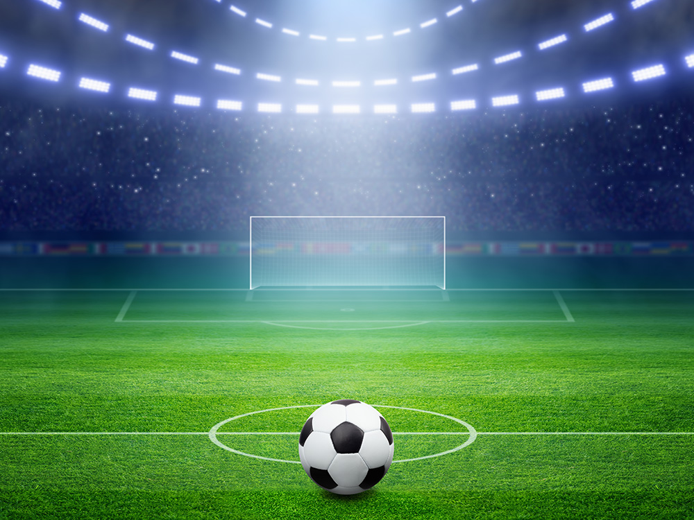 Papier peint photo - Football dans un stade sur un terrain vert devant un but sous des projecteurs