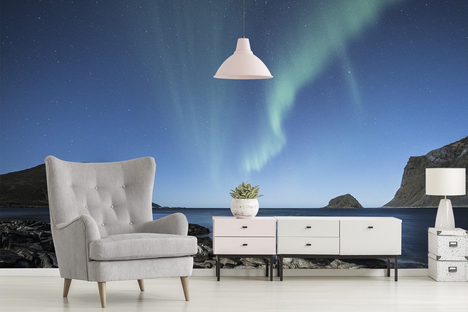 Papier peint photo - aurores boréales dans le ciel au-dessus d'une zone côtière tranquille, décorée avec un fauteuil moderne et une commode dans le salon