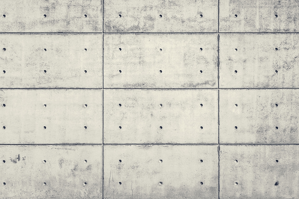 Papier peint photo - Mur moderne en béton avec des panneaux carrés et des trous de forage visibles